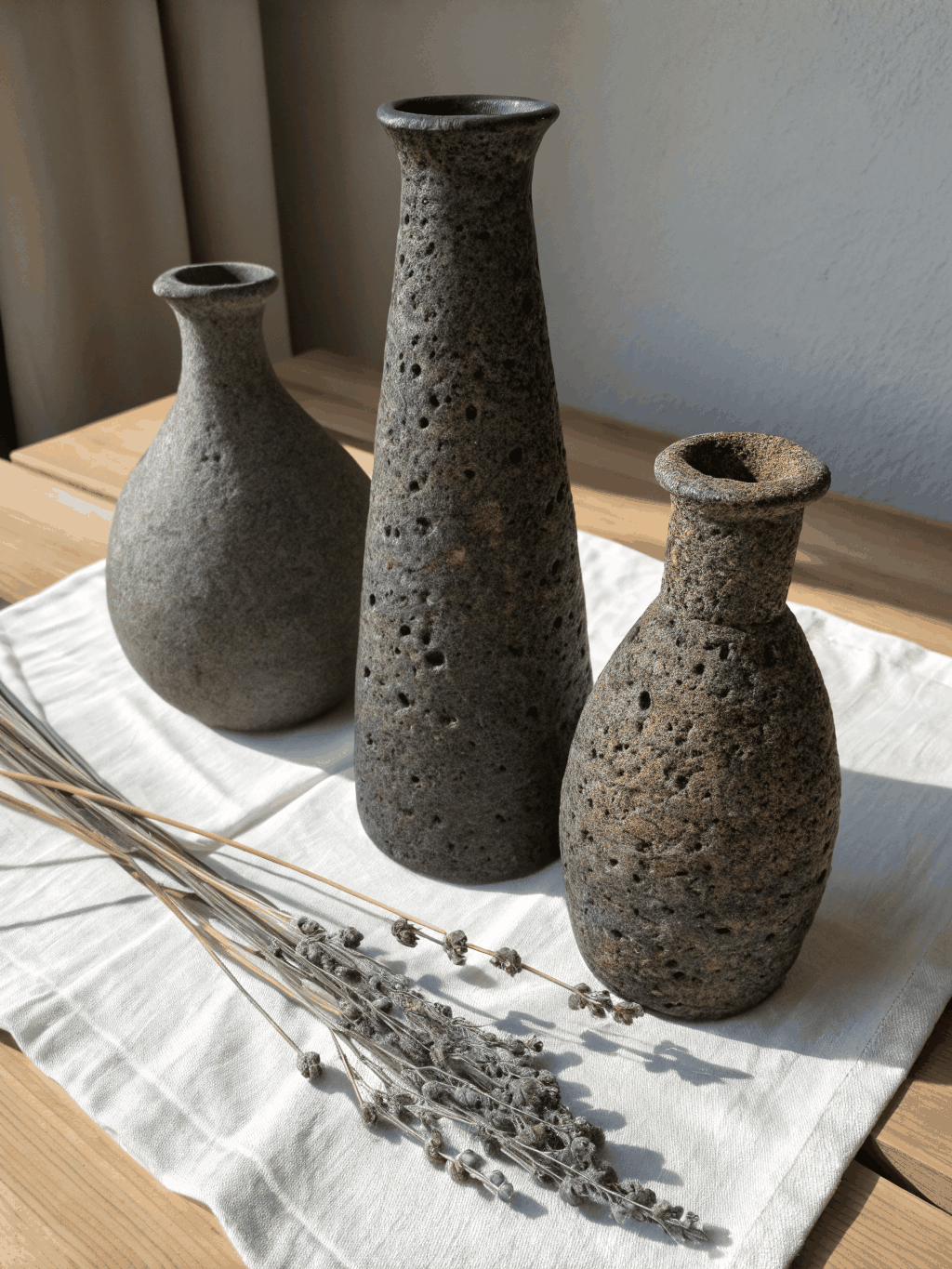 Hand-built ceramic pieces on a wooden studio table